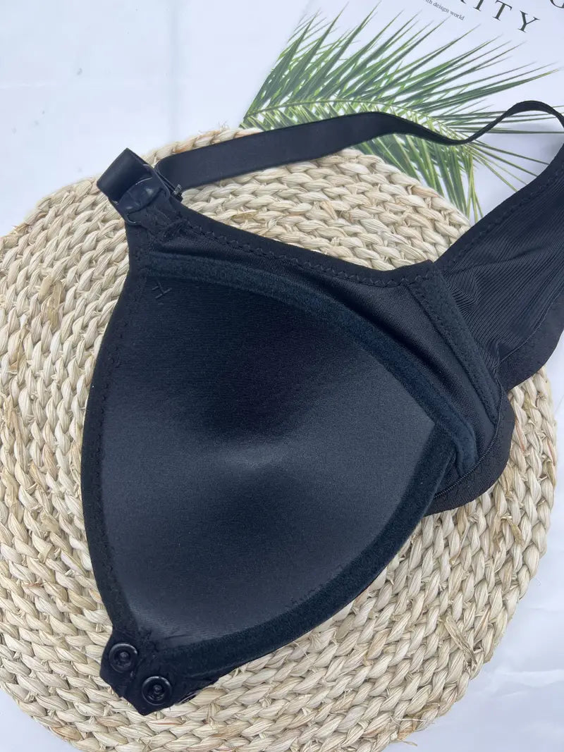 Schwarzer Bikini-Oberteil, gepolstert, verstellbare Träger, auf geflochtener Unterlage.