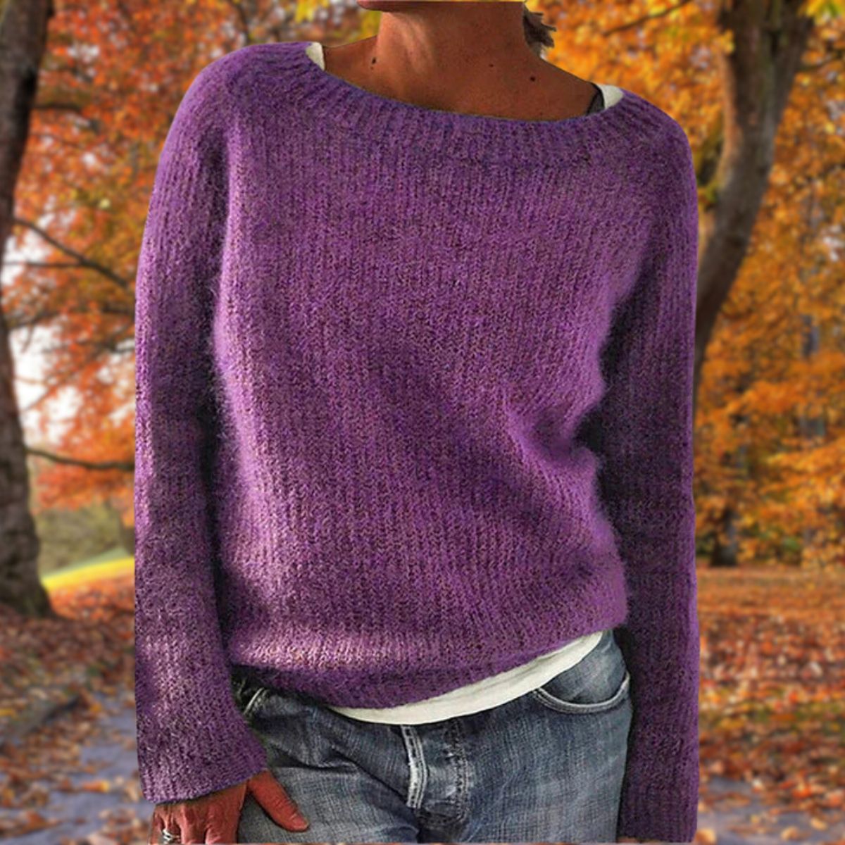 Lila stickad tröja med rund hals och långa ärmar, bärd av en modell över vitt linne och jeans i höstskogen. 7