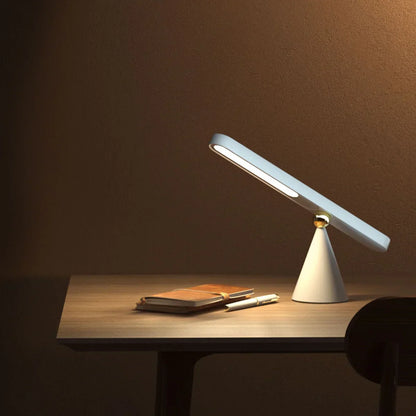 Moderne weiße LED-Tischlampe auf Holzschreibtisch mit Notizbuch und Stift, minimalistisches Design.