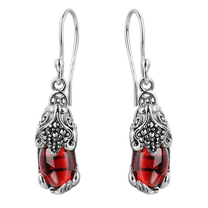 Silberne Ohrringe mit roten Edelsteinen, filigranes Design, Schmuck für Damen, elegant und stilvoll.