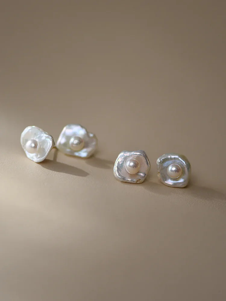 Perlenohrringe aus Silber mit unregelmäßiger Form auf beigem Hintergrund, eleganter Schmuck.
