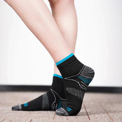 Schwarze Sportsocken mit blauen Akzenten, atmungsaktiv, auf Teppichboden.