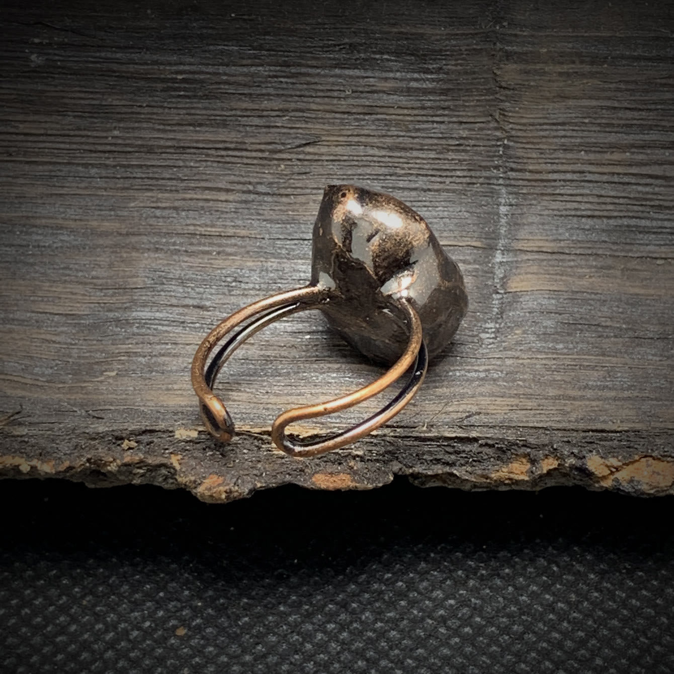 Rustikaler Silberring mit unregelmäßiger Form auf dunklem Holz, handgefertigter Schmuck.