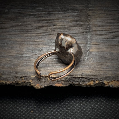 Rustikaler Silberring mit unregelmäßiger Form auf dunklem Holz, handgefertigter Schmuck.