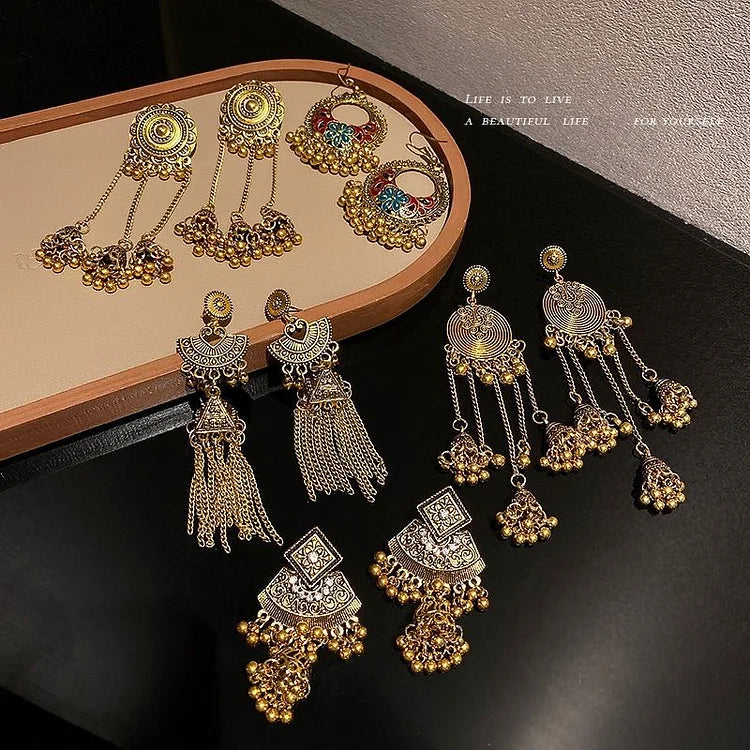 Verschiedene goldene und silberne Ohrringe mit filigranen Designs auf schwarzem Hintergrund.