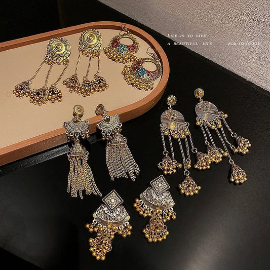 Verschiedene goldene und silberne Ohrringe mit filigranen Designs auf schwarzem Hintergrund.