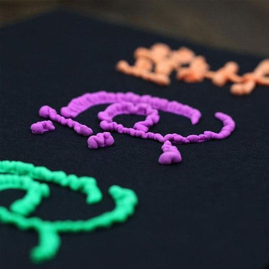 Bunte 3D-Schrift auf schwarzem Hintergrund, lila, grün, orange, kreative Kunst, Nahaufnahme.