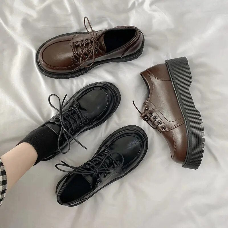 Schwarze und braune Leder-Derby-Schuhe auf weißem Hintergrund, modisch und robust.