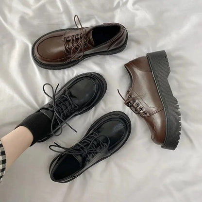 Schwarze und braune Leder-Derby-Schuhe auf weißem Hintergrund, modisch und robust.