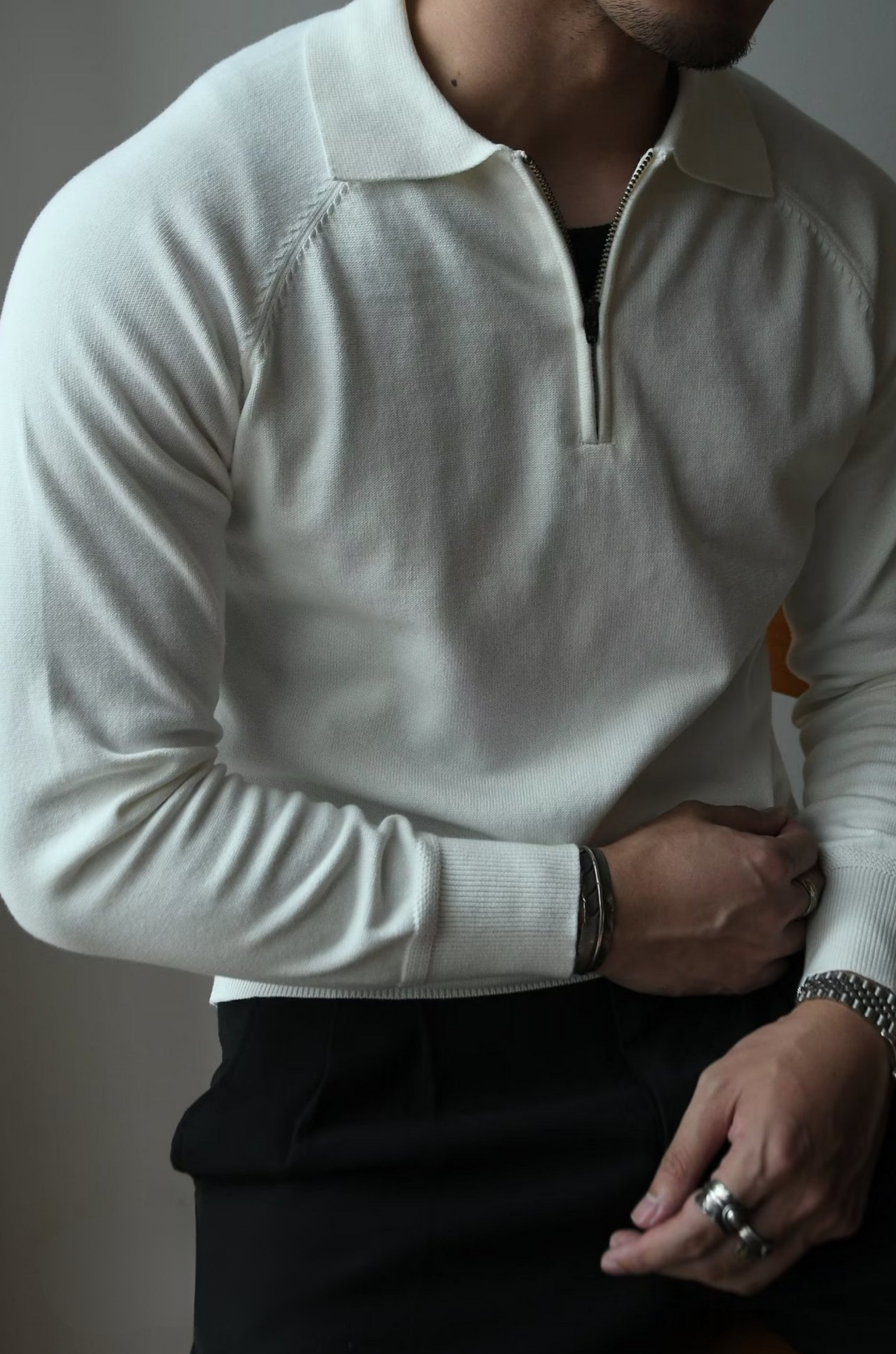Mann in cremefarbenem Langarm-Pullover mit Reißverschluss, eleganter Freizeitlook.