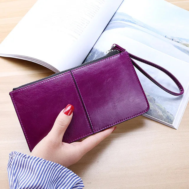 Lila Lederhandtasche mit Reißverschluss, Damenmode, elegantes Design, auf Holztisch.