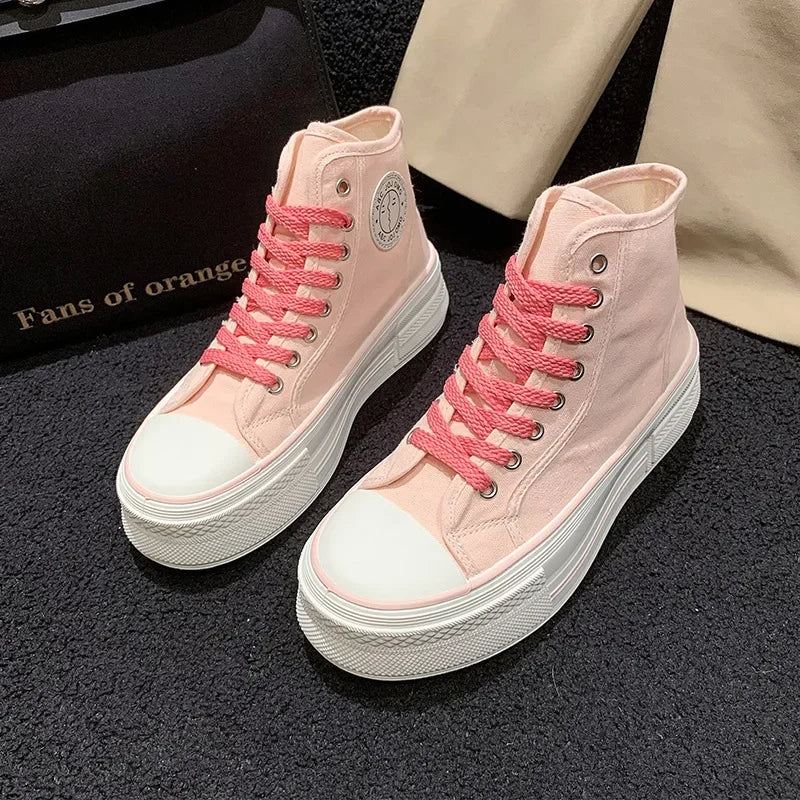 Rosa High-Top-Sneaker mit dicker Sohle und pinken Schnürsenkeln auf schwarzem Teppich.