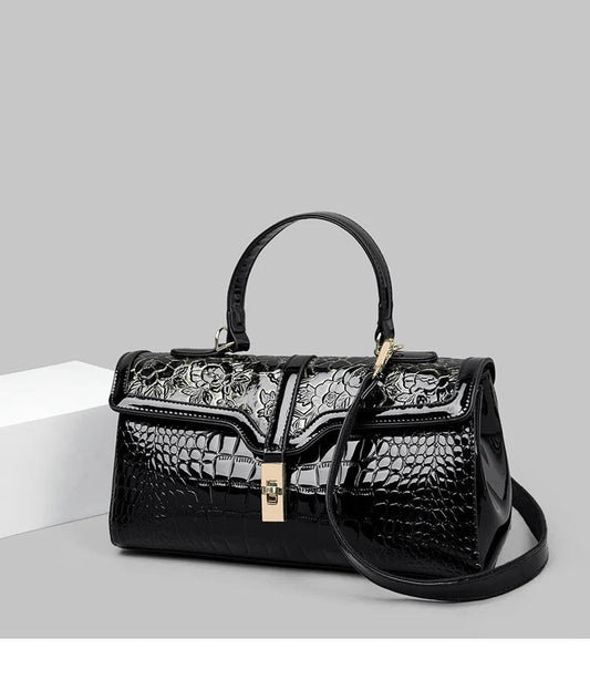 Schwarze Damenhandtasche aus Leder mit Krokodilprägung und Blumenmuster, elegant und stilvoll.