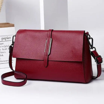 Rote Lederhandtasche mit verstellbarem Schulterriemen, elegant und modern für Damen.