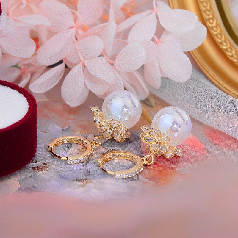 Goldene Ohrringe mit Perlen und Strass, eleganter Schmuck, ideal für festliche Anlässe.