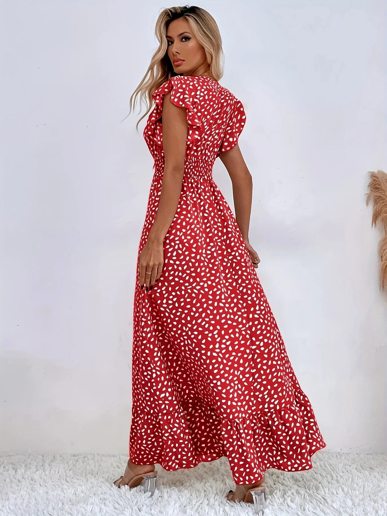 Frau in rotem Maxikleid mit weißen Punkten, Sommermode, elegantes Design, Damenbekleidung.