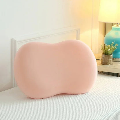 Rosa ergonomisches Nackenkissen aus Memory-Schaum auf Bett, ideal für Schlafkomfort.
