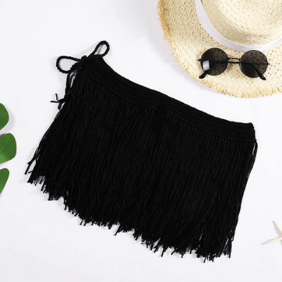 Schwarzer Fransenrock aus Baumwolle, ideal für Sommermode, neben Strohhut und Sonnenbrille.