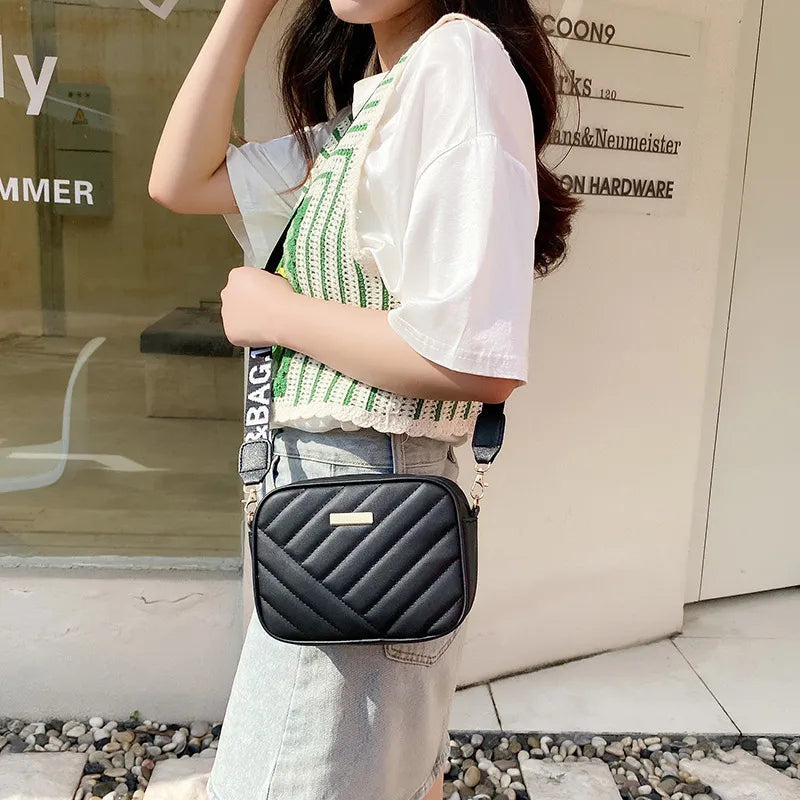 Frau mit schwarzer Umhängetasche, gesteppt, modisch, Sommeroutfit, lässig, Straße.