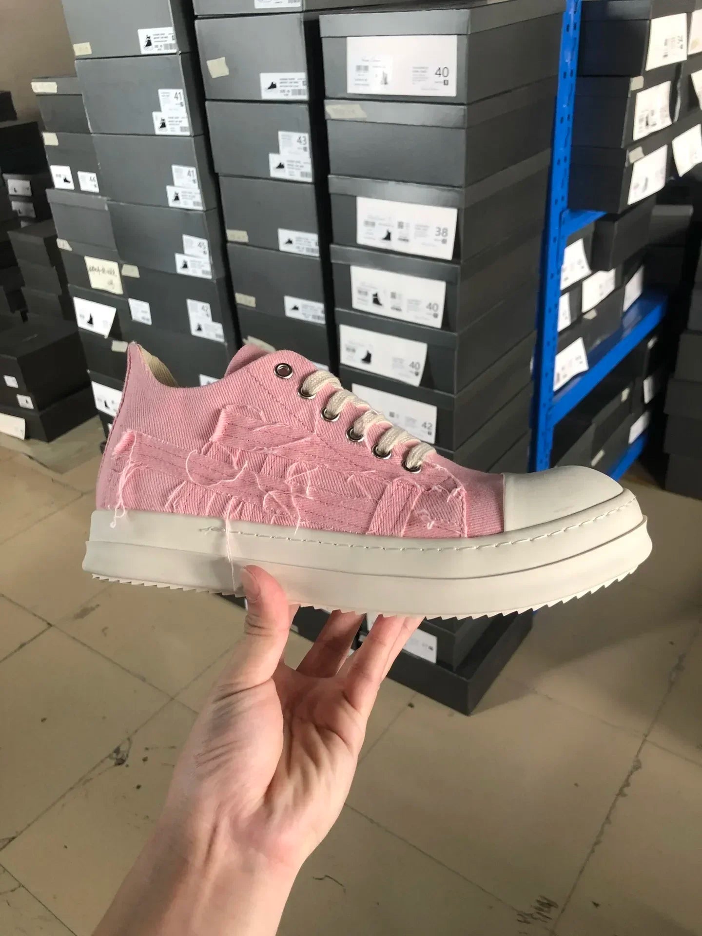 Rosa Sneaker aus Canvas, weiße Sohle, unisex, modisch, im Lager, Schuhkartons im Hintergrund.