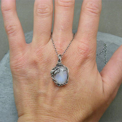 Silberkette mit Mondstein-Anhänger, handgefertigt, auf Hand präsentiert, Schmuckdesign.