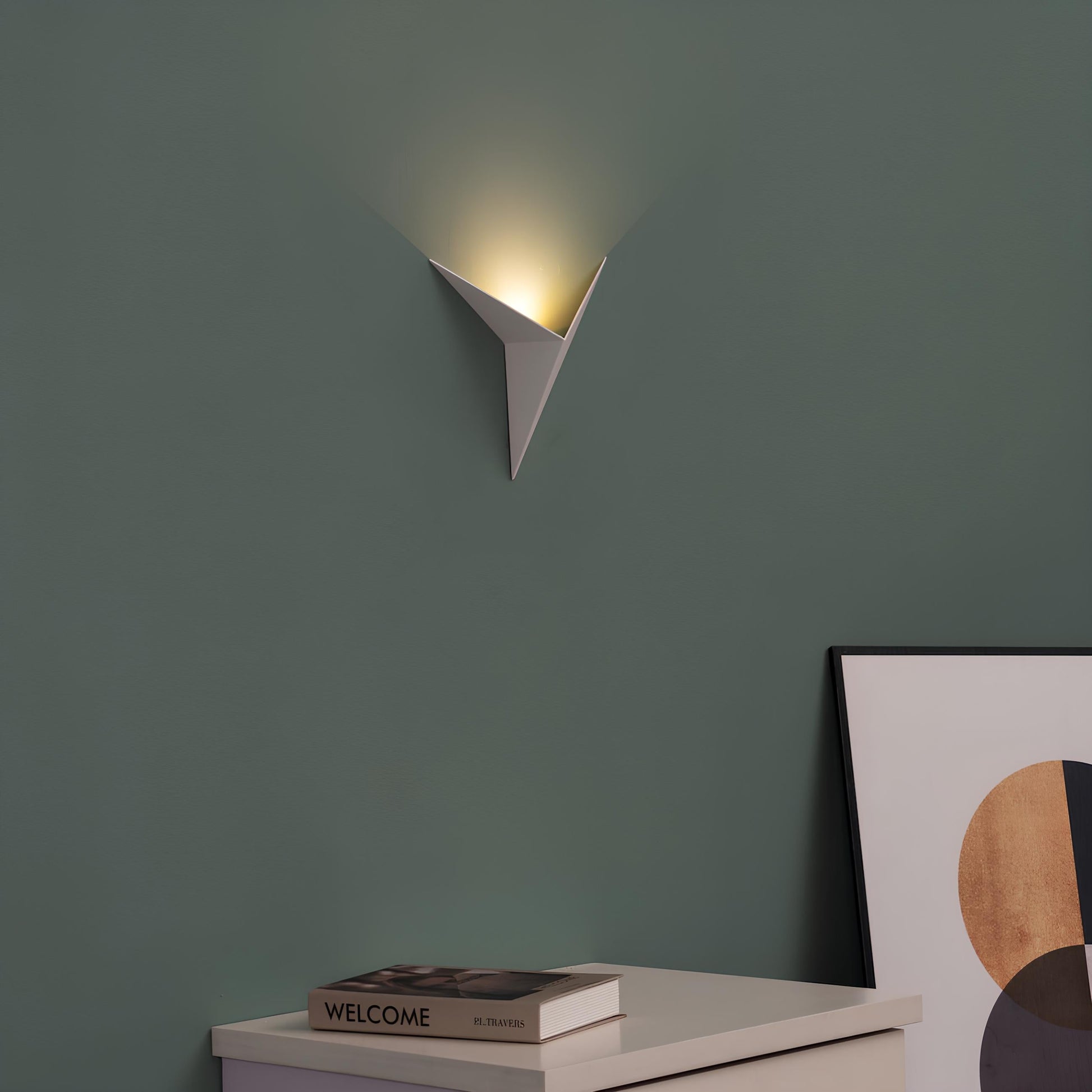 Moderne weiße Wandleuchte, dreieckig, minimalistisch, auf grüner Wand, stilvolle Inneneinrichtung.