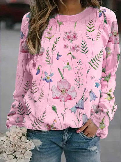 Frau in rosa Blumenpullover, Jeans, hält weißen Blumenstrauß, modisch, lässig, Frühling.