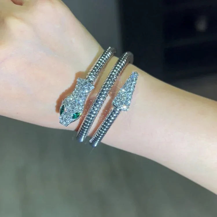 Silbernes Schlangenarmband mit Kristallen, Wickeldesign, funkelnd, modisch, Damenaccessoire.