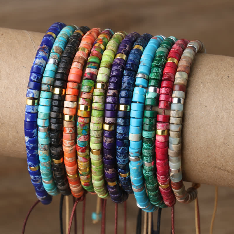 Bunte, handgefertigte Armbänder aus Naturstein, gestapelt auf Kartonrolle, Schmuck, Boho-Stil.
