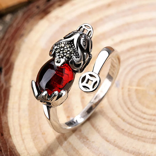 Silberring mit rotem Edelstein und Drachenmotiv, verstellbar, elegantes Schmuckdesign.