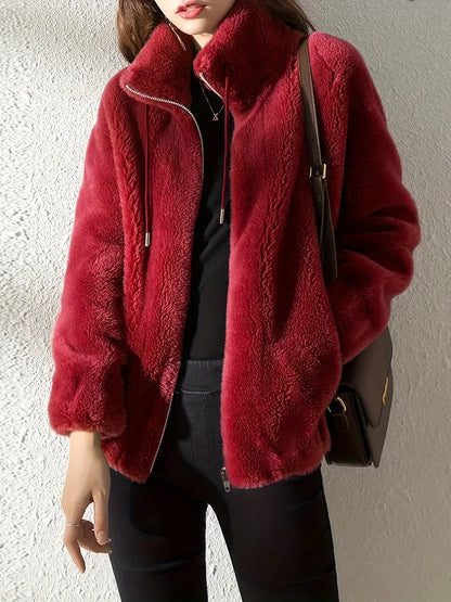 Frau in roter Kunstpelzjacke, Reißverschluss, schwarze Hose, modisch, elegant, Herbstmode.