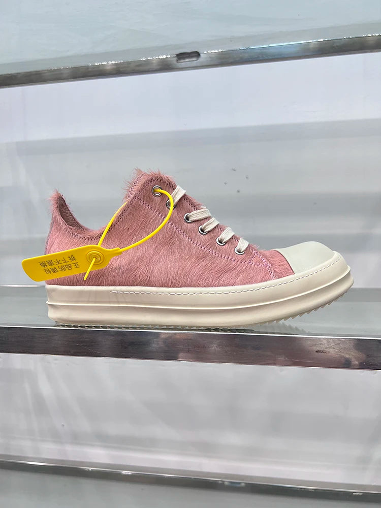 Rosa Sneaker mit Felloptik, weiße Sohle, gelbes Etikett, modischer Freizeitschuh.