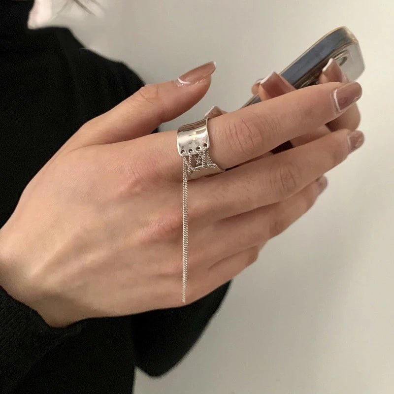 Silberner Ring mit Kette, Damenhand, Smartphone, eleganter Schmuck, modisches Accessoire.