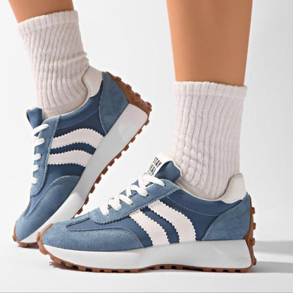 Blå skor med vita ränder, bäras av modell med vita ribbade strumpor, sedda från sidan 8