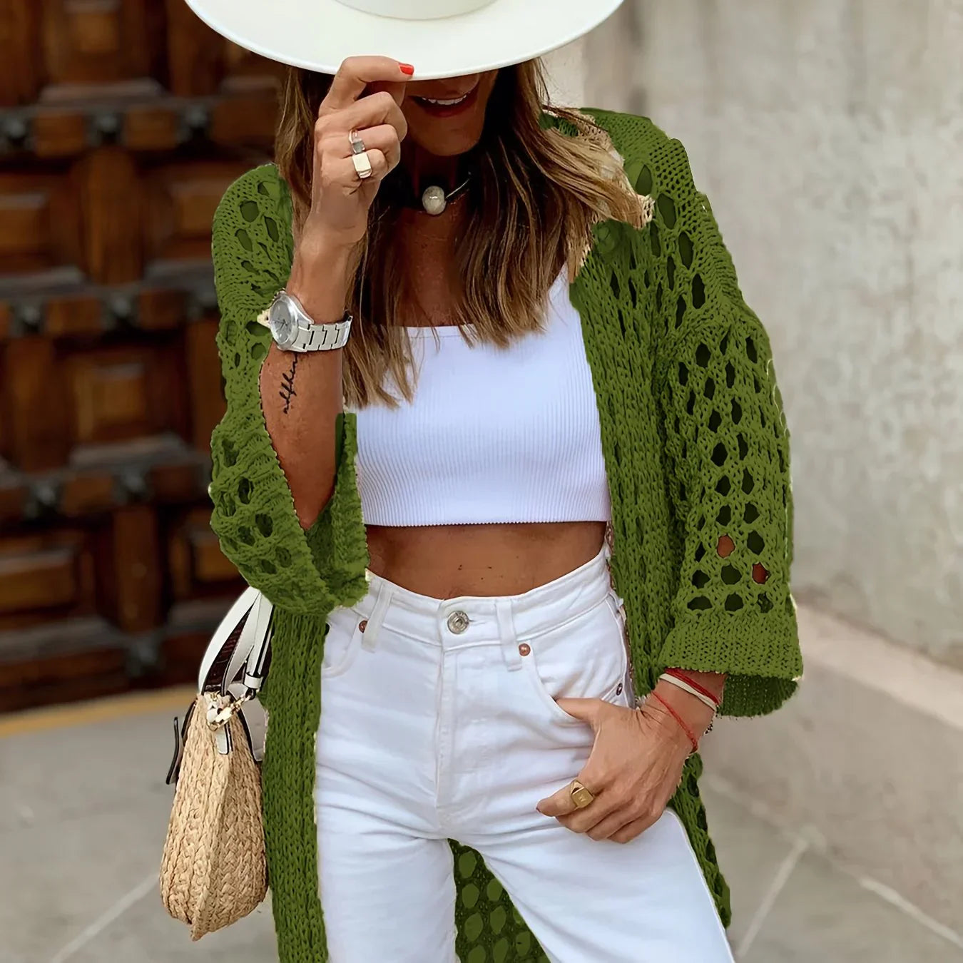 Frau in grünem Häkel-Cardigan, weißem Top und Hut, modisch, Sommeroutfit, Straße.