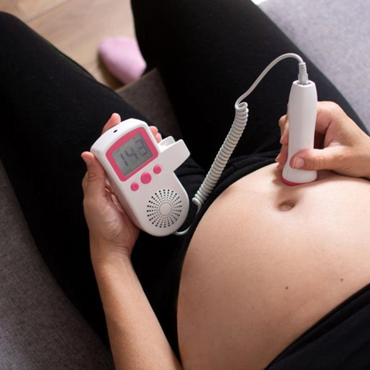 Schwangere Frau nutzt tragbares Fetal-Doppler-Gerät zur Herzfrequenzüberwachung zu Hause.