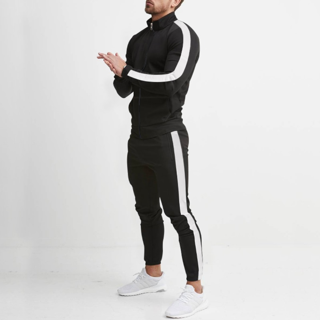 Mann in schwarzem Trainingsanzug mit weißen Streifen, weiße Turnschuhe, sportliche Kleidung.