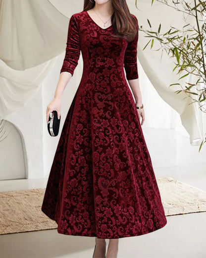 Frau in elegantem, rotem Samtkleid mit Blumenmuster, knielang, langärmlig, Abendmode.