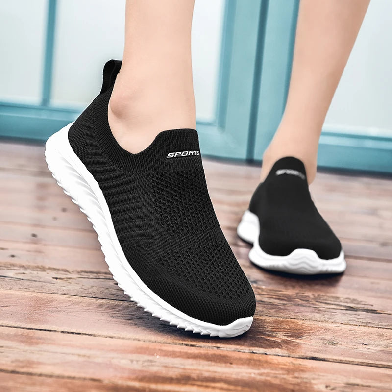 Schwarze Sportschuhe, atmungsaktiv, rutschfest, für Damen, auf Holzboden.