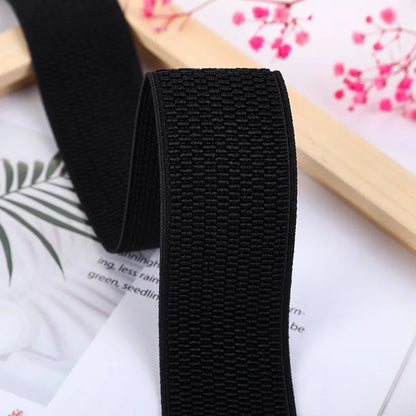 Schwarzes elastisches Band, gewebt, für Nähprojekte, 3 cm breit, auf floralem Hintergrund.
