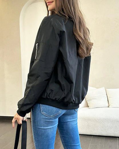 Frau in schwarzer Bomberjacke und blauer Jeans, modisch, lässig, urbaner Stil.