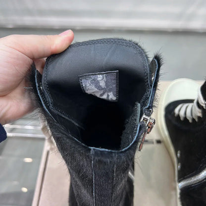 Schwarzer Lederstiefel mit Reißverschluss, Fellbesatz, handgehalten, modisch, robust.