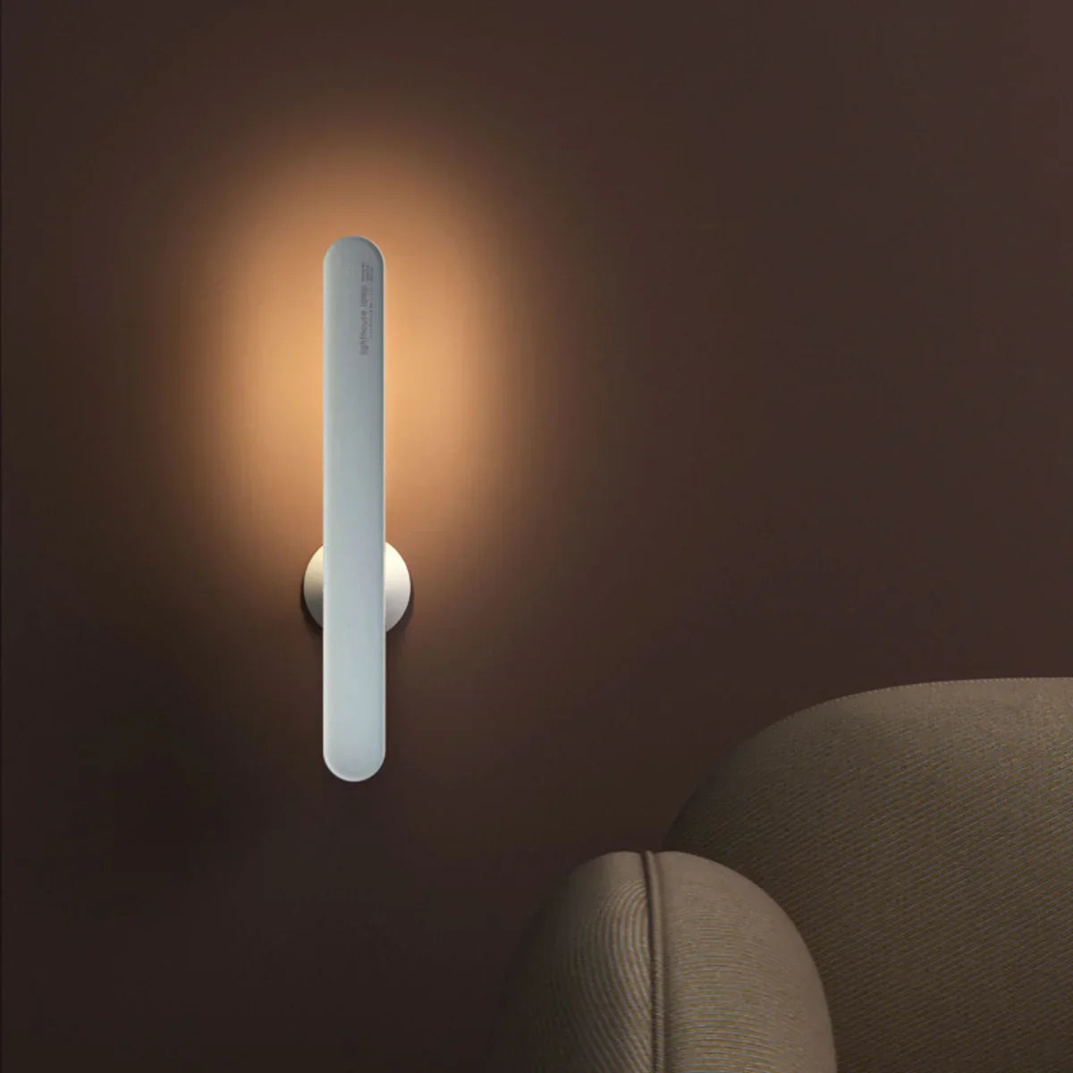 Moderne LED-Wandleuchte, vertikal, silber, warmweißes Licht, minimalistisches Design.