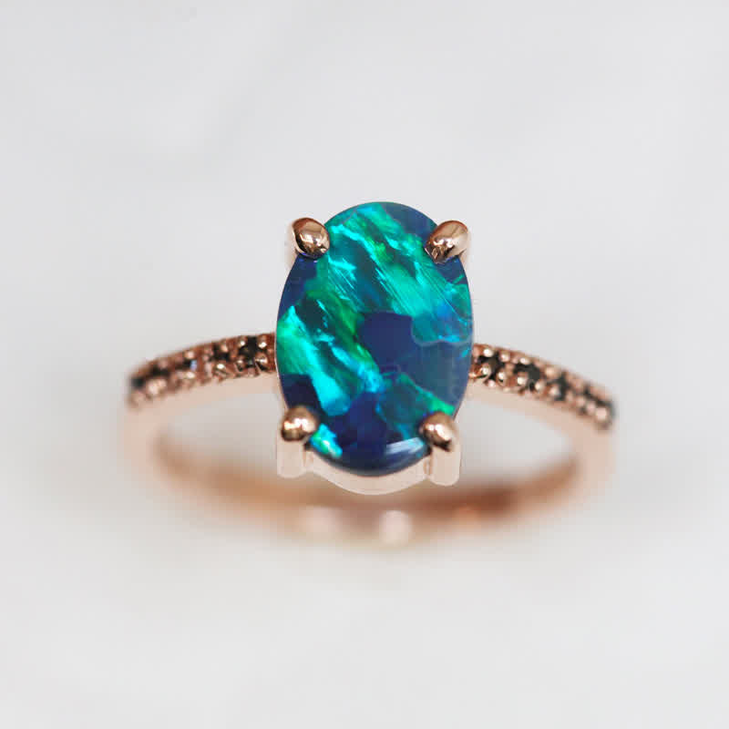 Opalring mit blau-grünem Stein, Roségold, Diamantakzente, eleganter Schmuck, Verlobungsring.