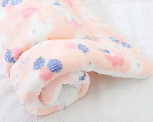 Weiche rosa Babydecke mit blauen und weißen Mustern, flauschig, kuschelig, Baumwolle.