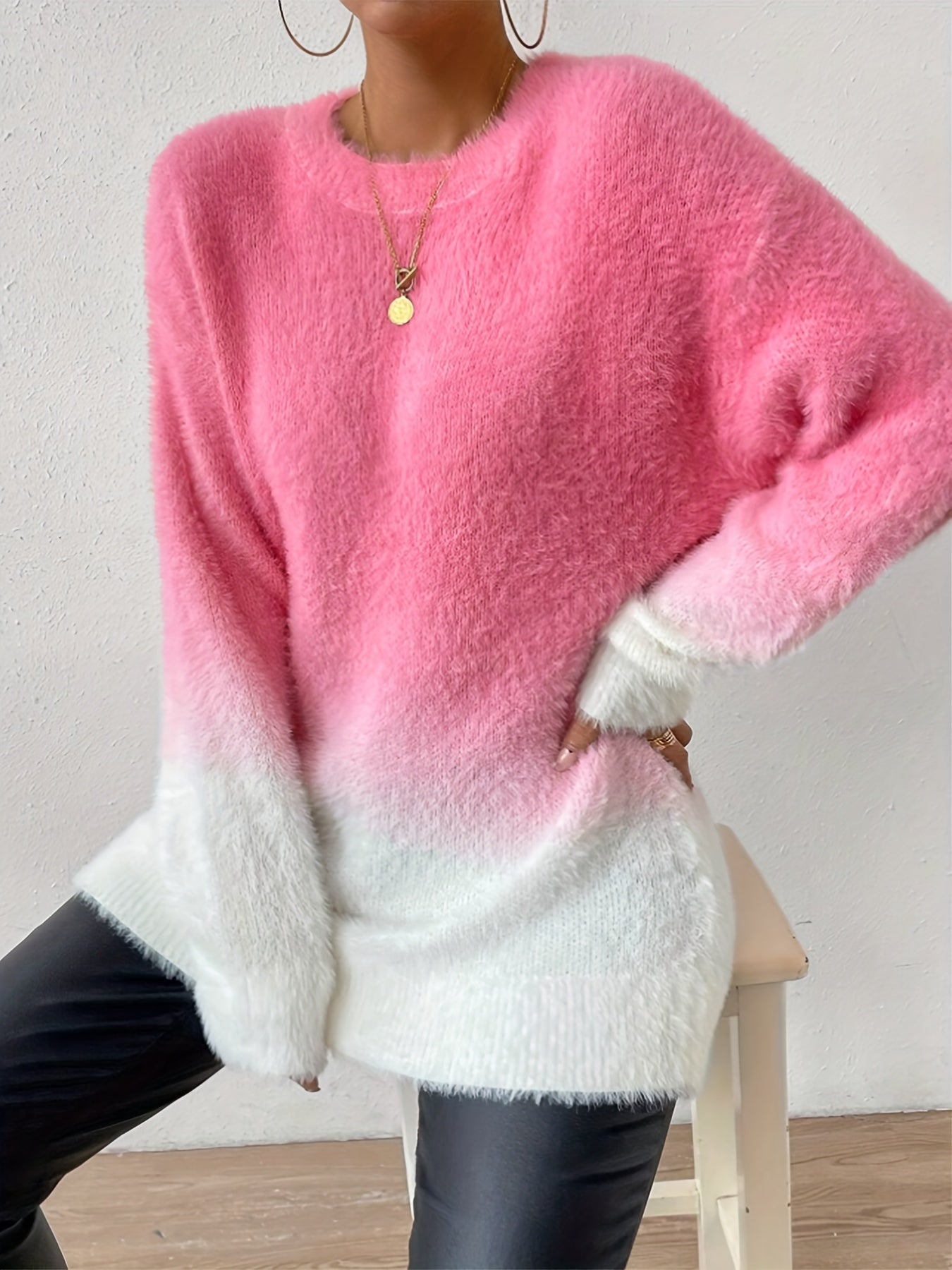 Frau in rosa-weißem Ombre-Pullover aus Mohair, kombiniert mit schwarzen Lederhosen.