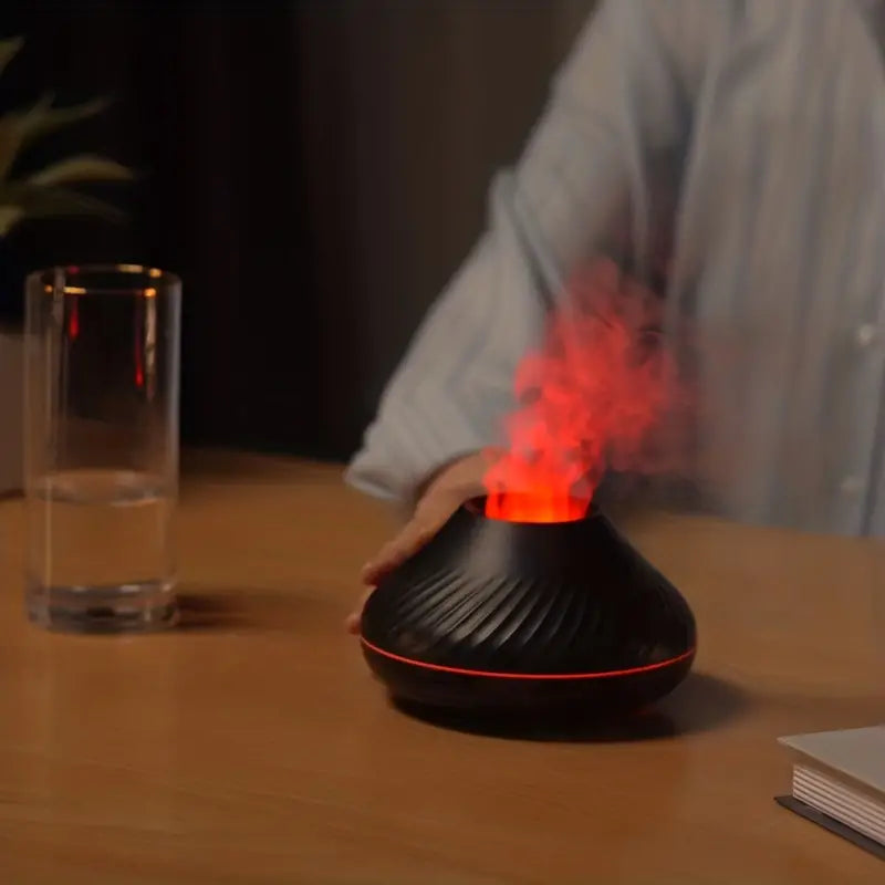 Schwarzer Aromadiffusor mit rotem LED-Licht und Rauch auf Holztisch, modernes Design.