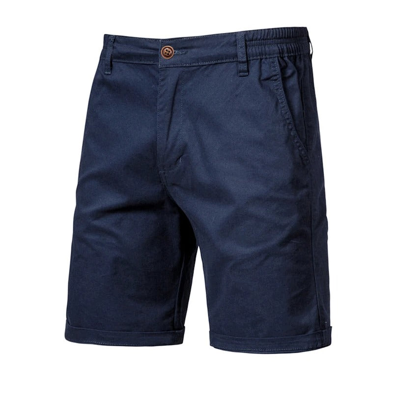 Marinblå shorts sedda framifrån med brun knapp, resår i sidan, snedfickor och uppvikta benslut. 10