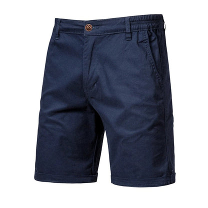 Marinblå shorts sedda framifrån med brun knapp, resår i sidan, snedfickor och uppvikta benslut. 10