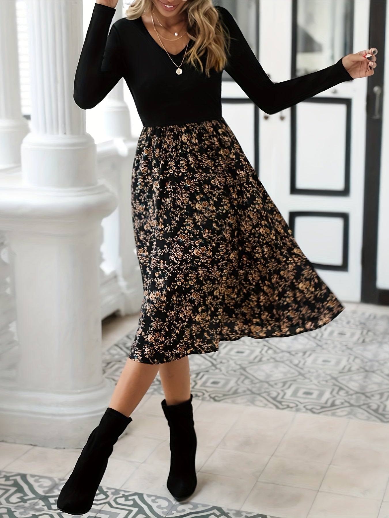 Frau in schwarzem Langarmkleid mit Blumenmuster, knielang, modisch, elegant, Herbstmode.